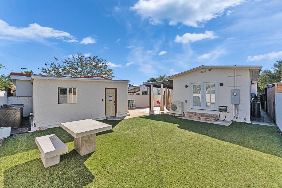 Backyard with turf lawn, concrete bench, and rear bungalow exterior — Atwater Village