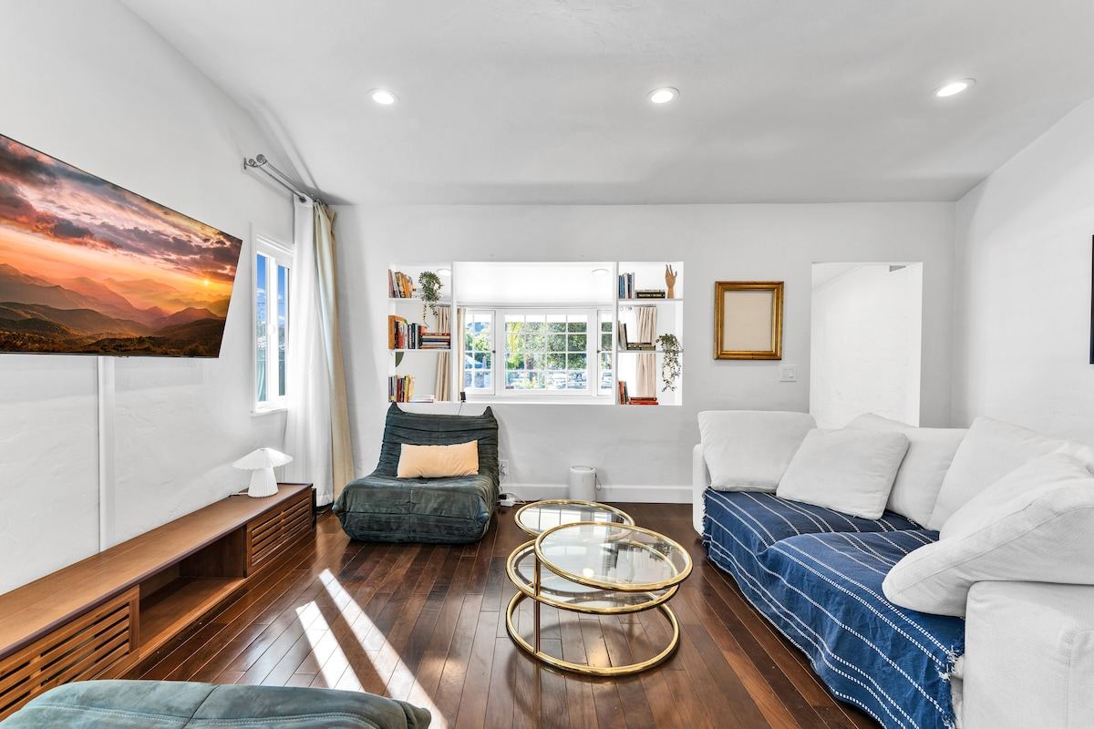 Bright living room with hardwood floors, blue-and-white sectional, and built-in bookshelves — Atwater Village