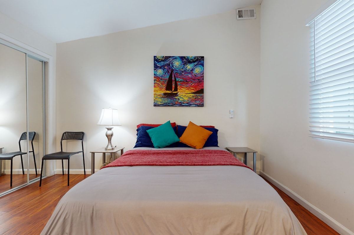 Guest bedroom with queen bed, side chairs, and vaulted ceiling — Hawthorne